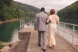bride and father walk to boat for wedding photography