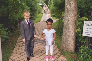 ring bearer and flower girl hold sign wedding day photography