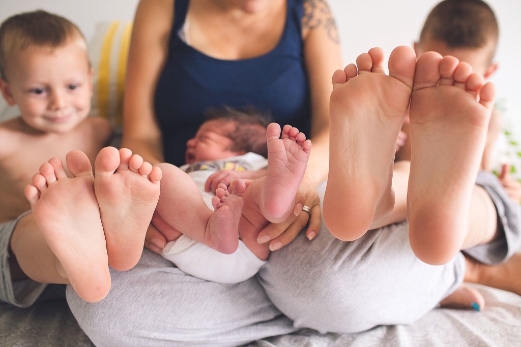 feet of new baby with brothers during frederick newborn photography session
