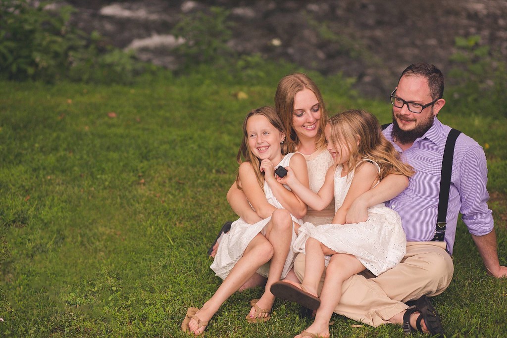 new family snuggles in grass after dc wedding ceremony for portrait photography