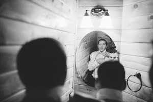groomsmen tie bow ties in mirror during baltimore wedding photography