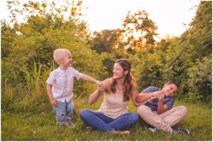 mom and boys playing at family photo session in field