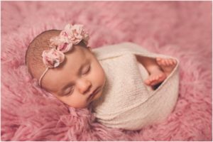Newborn girl wrapped with pink wrap by Baltimore newborn photographer